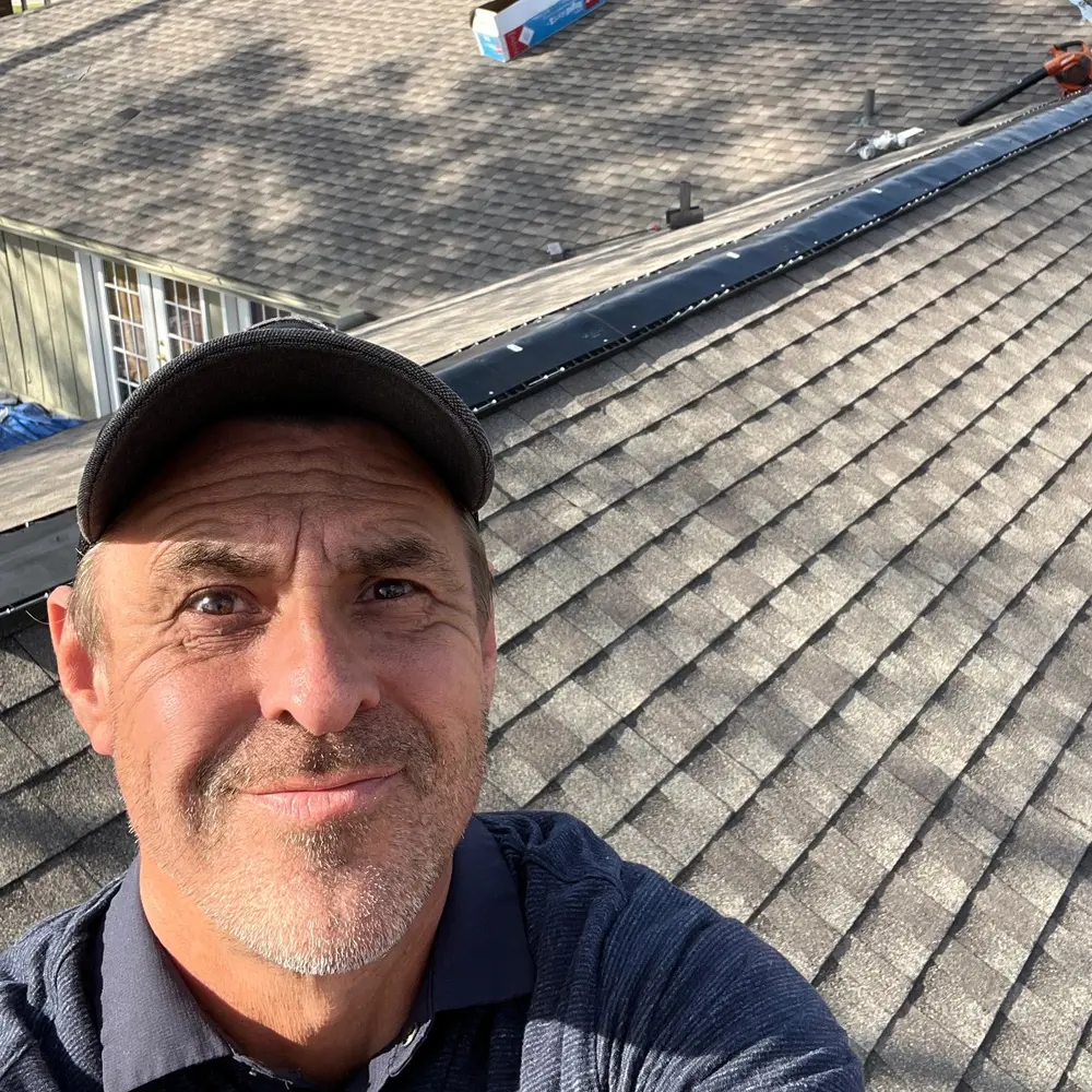 Robert Booker, owner of RoofPro Construction LLC, on a shingle roof